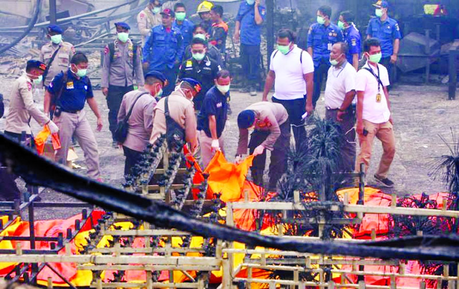 Indonesian police officers check dead bodies after an explosion at a fireworks factory at Kosambi village in Tangerang, Banten province, Indonesia October 26, 2017. Internet photo