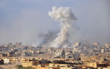 Smoke rises from buildings following an air strike by Syrian government forces in the eastern city of Deir Ezzor