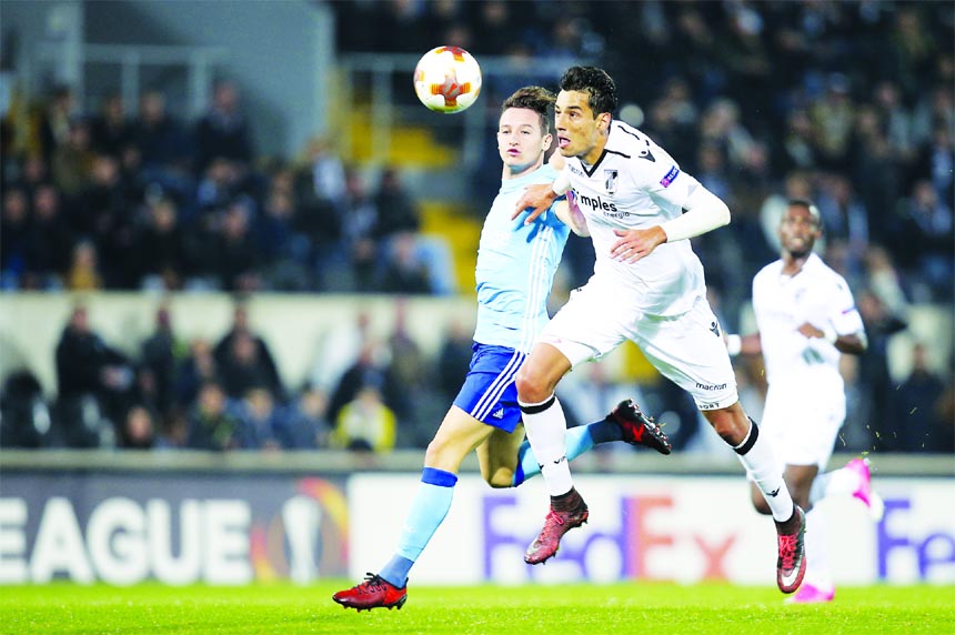 Vitoria's Marcos Valente jumps for the ball with Marseille's Florian Thauvin, left, during the Europa League group I soccer match between Vitoria SC and Olympique de Marseille at the D. Afonso Henriques stadium in Guimaraes, Portugal on Thursday.