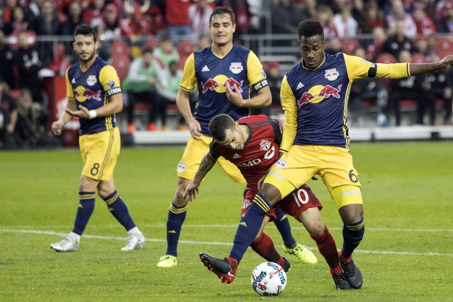 Toronto FC forward Sebastian Giovinco (10) goes down as he is brushed by New York Red Bulls defender Michael Murillo (62) during first-half MLS soccer game action in Toronto on Sunday.