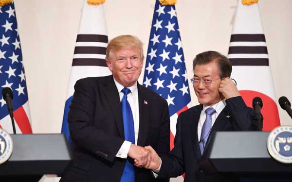 US President Donald Trump shakes hands with South Korea's President Moon Jae-In during a joint press conference at the presidential Blue House in Seoul on Tuesday.