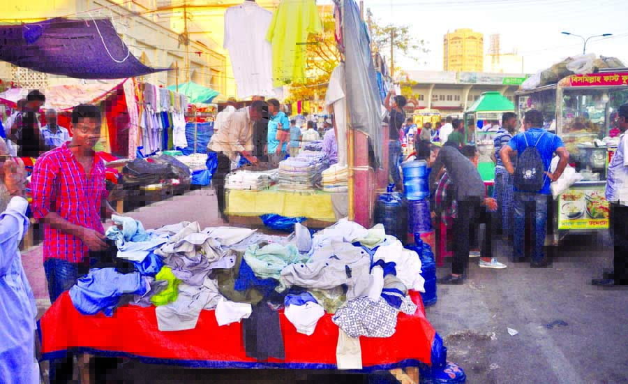 Busy footpaths in cityâ€™s Baitul Mukarram areas have been illegally occupied by hawkers again. This picuture was taken on Tuesday .
