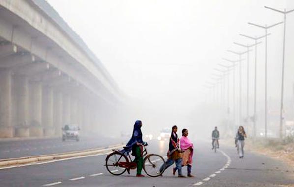 Indian schoolchildren cover their faces as they walk to school amid heavy smog in New Delhi on Wednesday.
