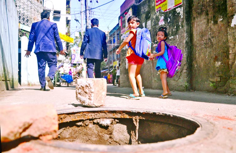 Pedestrians and school boys face endanger as uncovered Manhole being opened on the middle of the thoroughfare in city's Topkhana Road. But the authorities concerned do not pay any heed to repair it immediately. This photo was taken on Wednesday.