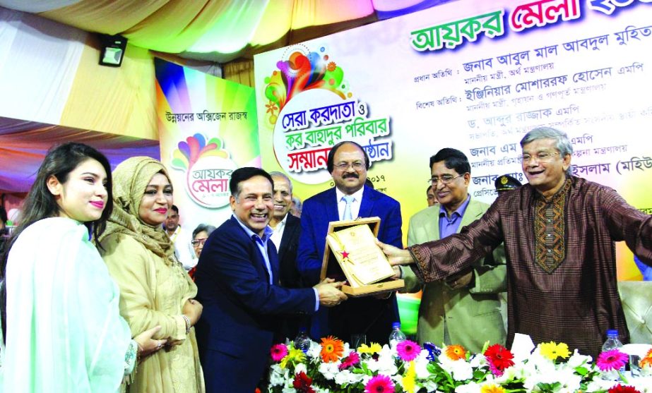 Abdus Salam Murshedy, Managing Director of Envoy Group and Chairman of Exporters' Association of Bangladesh (EAB) receiving the 'Kar Bahadur Paribar' award and 'Tax Card' from State Minister for Finance and Planning MA Mannan, at the closing ceremony