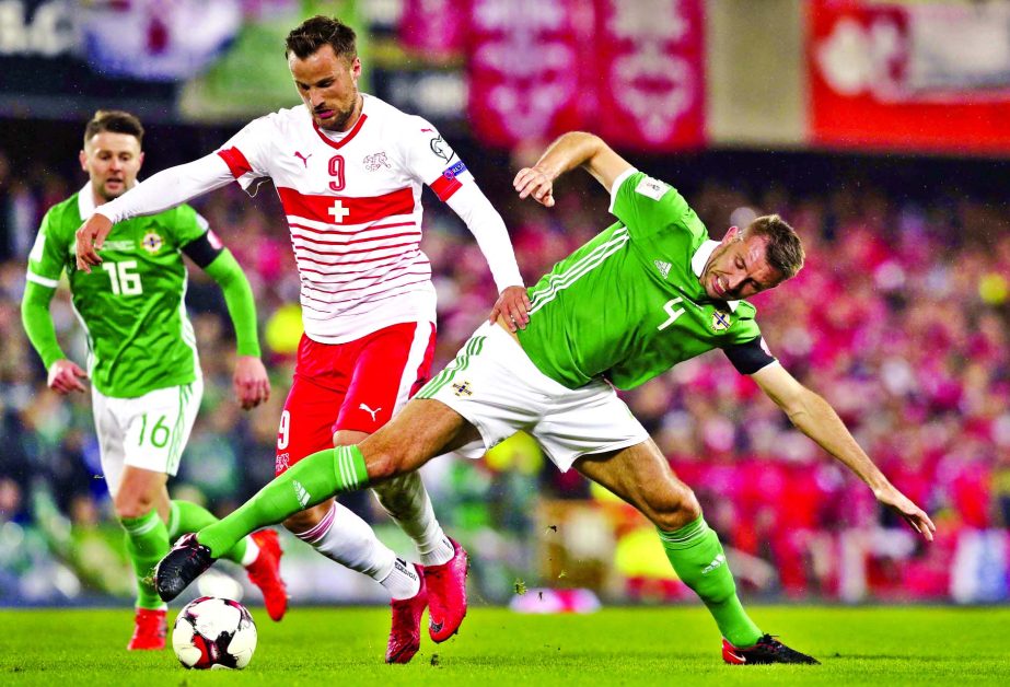 Switzerland's Haris Seferovic and Northern Ireland's Gareth McAuley (right) battle for the ball during the World Cup qualifying play-off first leg soccer match between Northern Ireland and Switzerland at Windsor Park in Belfast, Northern Ireland on Thur