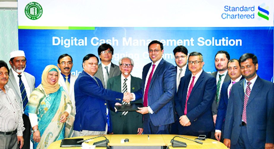 Debasish Chakrabarty, Managing Director of Bangladesh House Building Finance Corporation (BHBFC) and Naser Ezaz Bijoy, CEO of Standard Chartered Bank, exchanging an agreement signing documents on Digital Cash Management Solution at the bank's head office