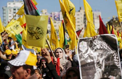Fatah supporters wave the party flag as they take part in a rally in Gaza City on Saturday to commemorate the anniversary of the death 13 years ago of veteran leader Yasser Arafat .