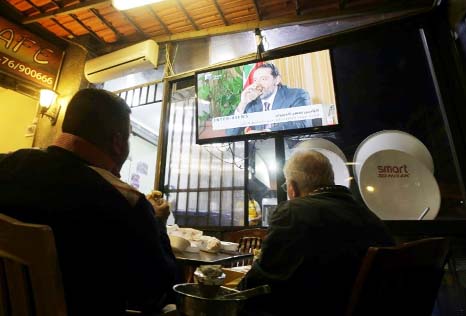 Lebanese watch an interview with resigned prime minister Saad Hariri at a coffee shop in Beirut.