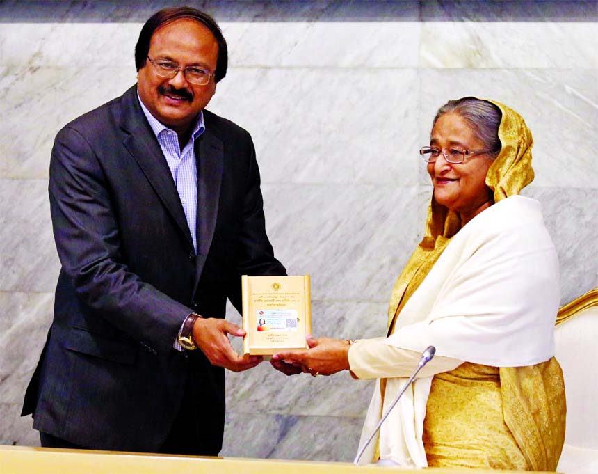 Prime Minister Sheikh Hasina receiving the income tax card as a regular taxpayer from NBR Chairman Md Nojibur Rahman at PMO on Monday.