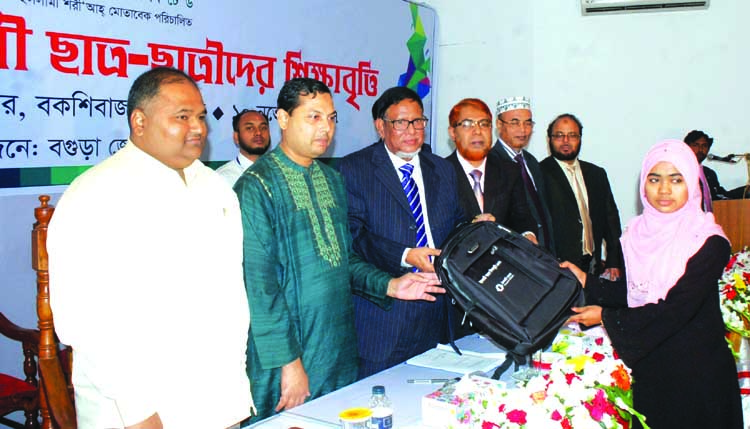 Dr. Md. Zillur Rahman, Chairman, Audit Committee of Islami Bank Bangladesh Limited, handing over scholarship and education materials among students of Bogra Zone at a local convention center on Friday. Abdus Sadeque Bhuiyan, DMD, Taher Ahmed, SEVP, Md. Mo