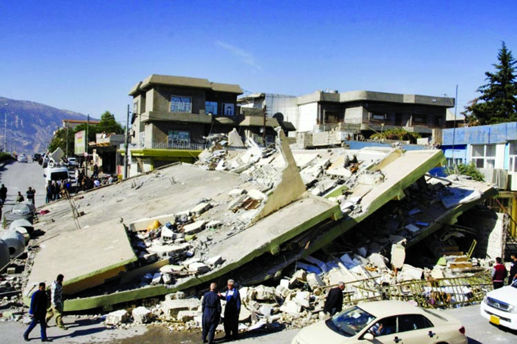 People gather around a levelled building in the mountainous town of Darbandikhan in Iraqi Kurdistan following a 7.3-magnitude earthquake that hit the Iraq-Iran border area. Internet photo