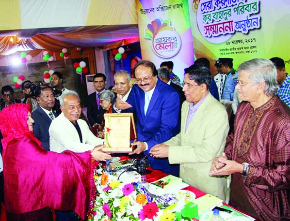 NARSINGDI: Eminent social worker of Narsingdi and Chairman of Tharmax Group Abdul Kader Mollah receiving ' Kor Bahadur Paribar and highest tax payer award from the State Minister for Finance MA Mannan at a function atNBR Bhaban recently.