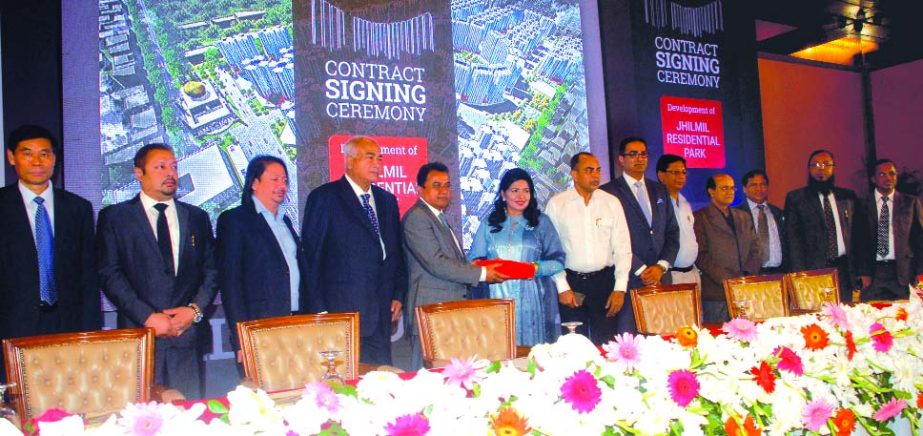 Rajuk Chairman Md Abdur Rahman and CEO of BNG Global Holding Limited Dr Sharifah Sabrina, exchanging a tri-nation consortium comprising agreement signing documents on "Development of Jhilmil Residential Park" of Rajdhani Unnayan Kartripakkha (RAJUK) at