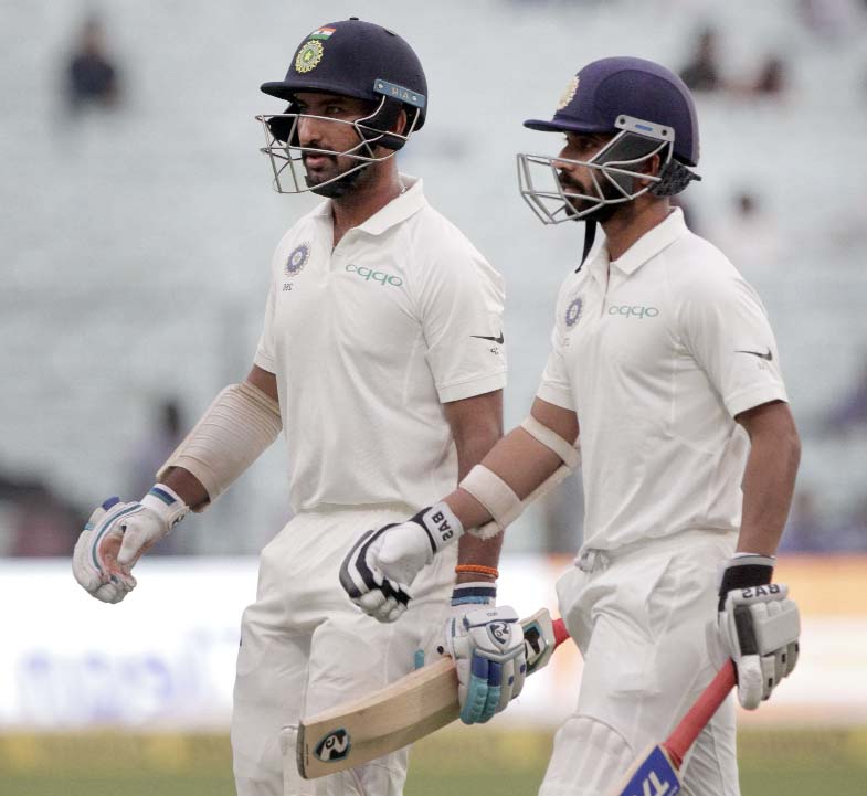 India's Ajinkya Rahane (left) and Cheteshwar Pujara leave the field after bad light stopped the play during the first day of their first Test cricket match against Sri Lanka in Kolkata, India on Thursday.