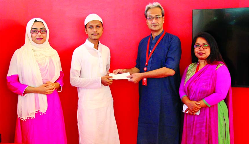 Ekram Kabir, Vice-President, Communication and Corporate Responsibility of mobile phone operator Robi, handing over a cheque of Tk one lakh among the winners of Hammd-Naat contest at its corporate office in the city recently.