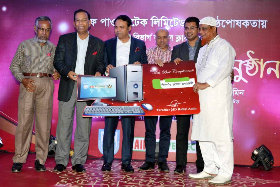 Secretary of Youth and Sports of Bangladesh Awami League Harunur Rashid (second from the left) and Chairman of the Saif Powertec Limited Tarafder Md Ruhul Amin (third from the left) distribute the computer to a representative of the Dhaka Metropolis Third