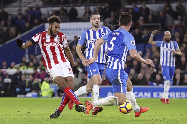 Stoke City's Eric Maxim Choupo-Moting (left) scores his side's first goal of the game against Brighton & Hove Albion during their English Premier League soccer match at the AMEX Stadium in Brighton, England on Monday.