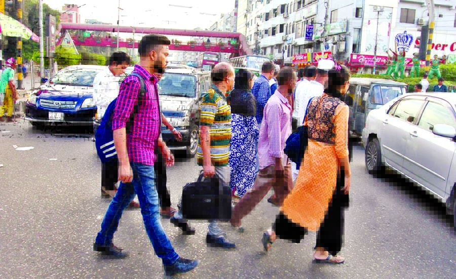 Pedestrians walking through the very busy road adjacent to foot-over bridge at Banani's Kakoli area in the city risking the life but traffic police remain indifferent to stop the walking. This photo was taken yesterday.