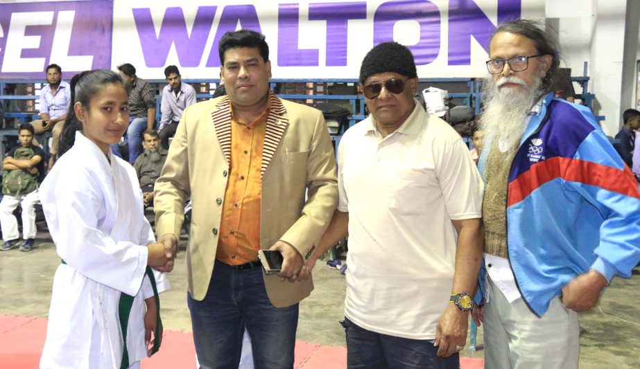 Operative Director (Head of Sports & Welfare Department) of Walton Group FM Iqbal Bin Anwar Dawn (second from left) shaking hands with a participant of Walton National Martial Art Competition at the gymnasium of National Sports Council on Wednesday.