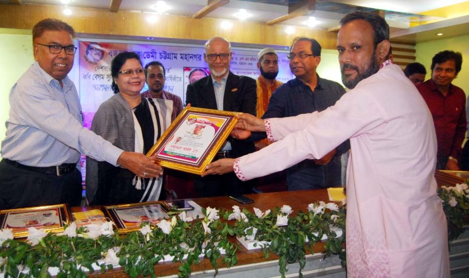 Dr SM Moniruzzaman, DIG, Chittagong Range handing over a honorary crest to Barun Kumar Acharjo Bolai, President of the Gowsia Hoque Commite Suyragari Asrom Branch for his Maizbhandari research works on the occasion of 18th death anniversary of Poet