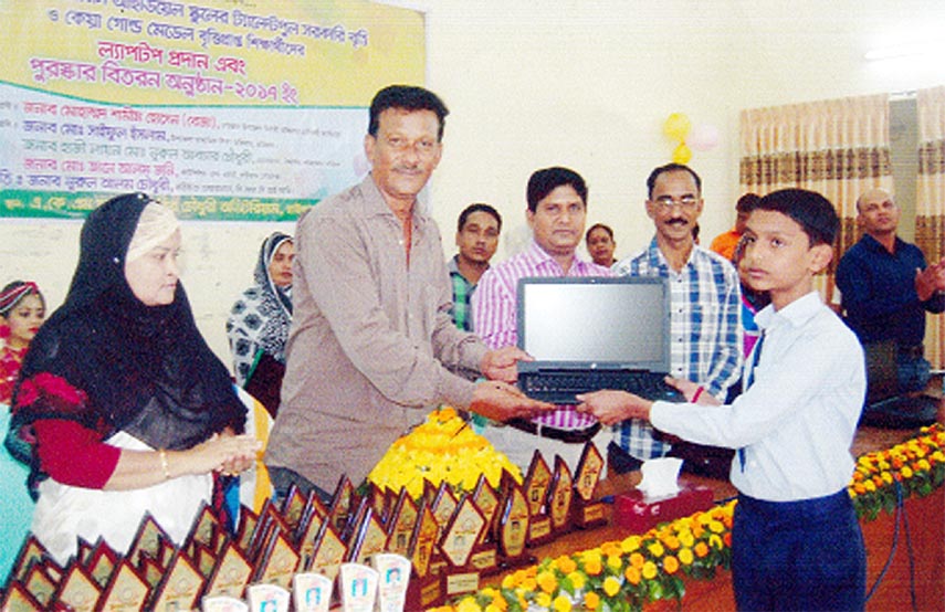 Founder Chairman of BRC Ideal Kindergarten School of Raozan, Chittagong Nurul Alam Chowdhury handing over laptop to a successful talent-pool scholarship awarded student of the school at the annual prize giving ceremony of the school recently.