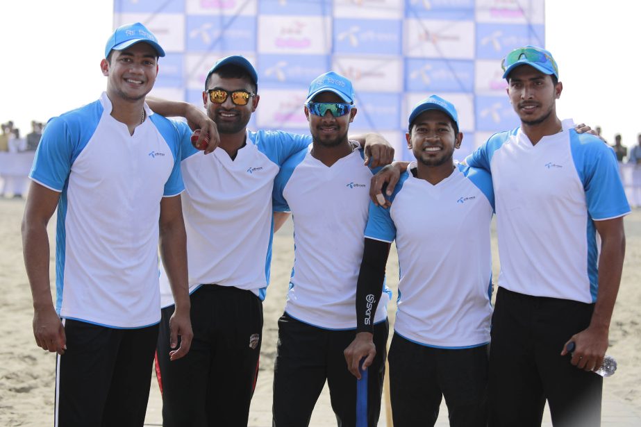 The national cricketers pose for a photo session before taking part in the exhibition cricket match with their fans at the Cox's Bazar Sea Beach on Wednesday.