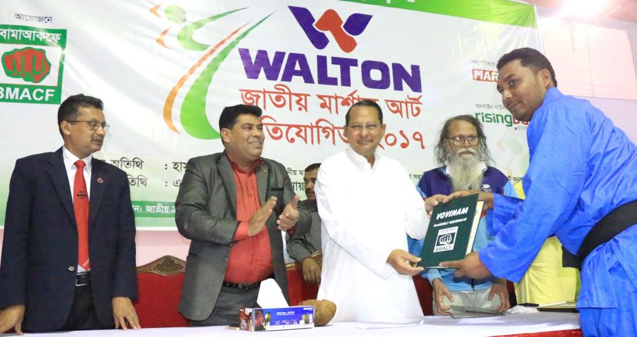 Minster for Information Hasanul Haq Inu distributes a certificate to a winner of the Walton National Martial Art Competition at the Gymnasium of National Sports Council on Thursday.