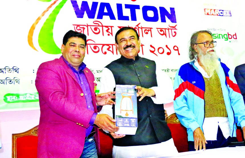 Operative Director (Head of Sports & Welfare Department) of Walton Group FM Iqbal Bin Anwar Dawn (left) handing over a gift to Shipping Minister Shahjahan Khan at the Gymnasium of National Sports Council on Friday.