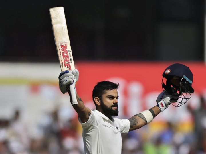 India's captain Virat Kohli raises his bat and helmet to celebrate scoring a century during the third day of their second Test cricket match against Sri Lanka in Nagpur, India, Sunday.