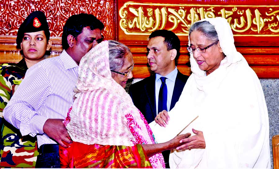 Prime Minister Sheikh Hasina handing over cheque of financial aid among the families of those who were killed and injured in the attacks of separatists and petrol bombs. The snap was taken from the Prime Minister's Office on Monday. BSS photo