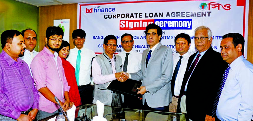 Mohammad Masoom, Managing Director of BD Finance Limited and Md. Samsul Alam, Executive Director of Socio Economic Health Education Organization (SEHEO) exchanging an agreement signing documents at BD Finance head office in the city on Tuesday. Senior off