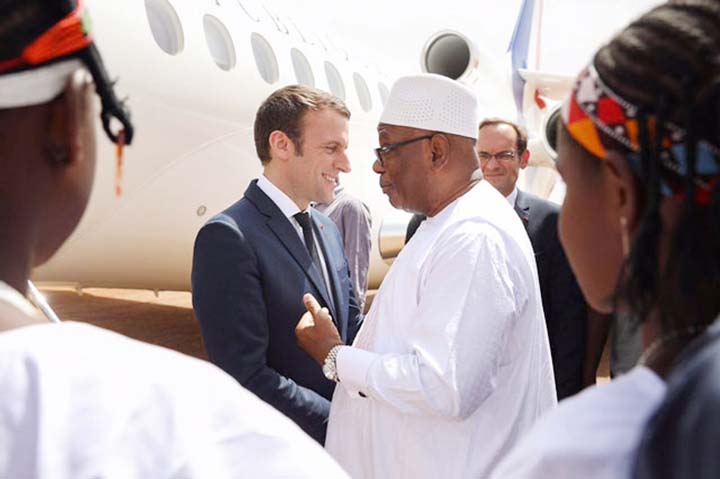 French President Emmanuel Macron is welcomed by Burkina Faso's President Roch Marc Christian Kabore (right) at Ouagadougou airport, Burkina Faso on Monday