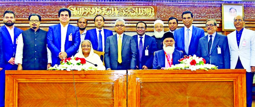 Prime Minister Sheikh Hasina poses for a photo session after receiving fifty thousand pieces of blankets as donation to support the cold-hit people of the country from Social Islami Bank Limited at PMO on Monday. Professor Md. Anwarul Azim Arif, Chairman,