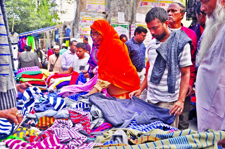 Buyers are active to buy winter clothes at makeshift markets in front of Baitul Mukarram Mosque at the advent of winter on Wednesday.