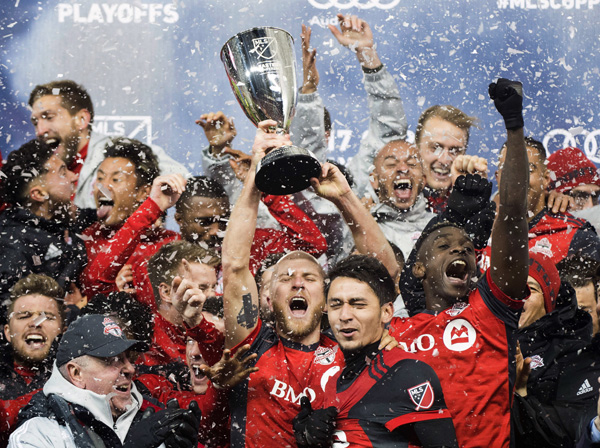 Toronto FC midfielder Michael Bradley (center) hoists the Eastern Conference championship trophy after defeating the Columbus Crew to advance to the MLS Championship finals in Toronto on Wednesday.