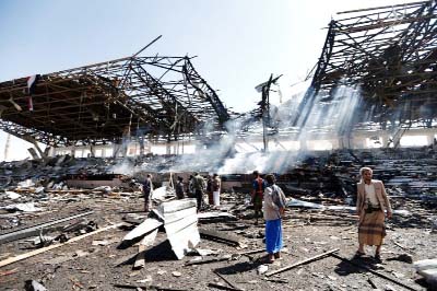 Yemeni men inspect the site of an air strike in the capital Sanaa.