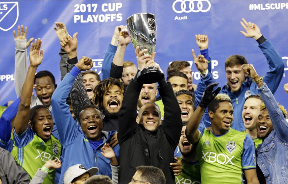 Seattle Sounders' midfielder Osvaldo Alonso (center) lifts the trophy after the Sounders won the MLS soccer Western Conference final against the Houston Dynamo on Thursday in Seattle. The Sounders won 3-0 giving them a 5-0 aggregate win in the two-leg