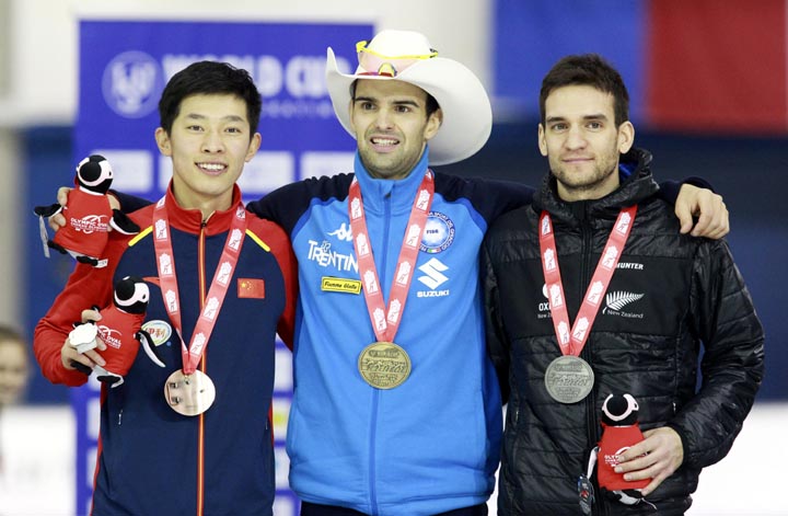 First-place Andrea Giovannini (center) of Italy is flanked by second-place Reyon Kay (right) of New Zealand, and third-place Hongli Wang, of China, on the podium for the men's mass start at the World Cup speedskating event in Calgary, Alberta on Sunday.
