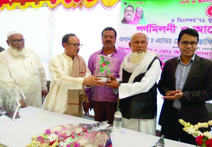 DINAJPUR(South): Primary and Mass Education Minister Mostafizur Rahman Fizar MP handing over a crest to freedom fighter Md Moksad Ali Shah at the reception marking the Fulbari Freedom Day on Monday.