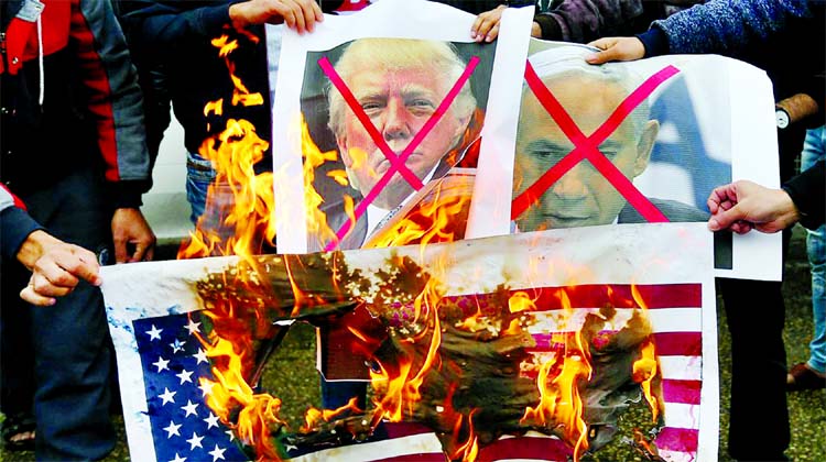 Palestinians burn posters depicting Israeli Prime Minister Benjamin Netanyahu and US President Donald Trump during a protest against the US intention to move its embassy to Jerusalem and to recognise the city of Jerusalem as the capital of Israel, in Rafa
