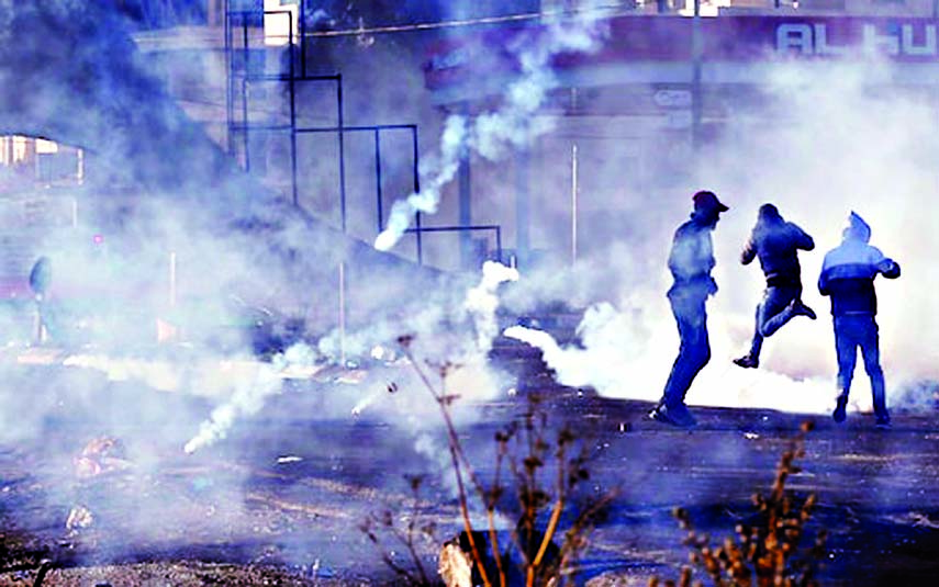 Palestinian demonstrators react to tear gas fired by Israeli troops during clashes at a protest against U.S. President Donald Trump's decision to recognize Jerusalem as the capital of Israel, in the West Bank city of Bethlehem on December 9, 2017. Inter