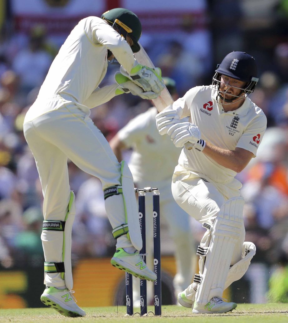 England's Jonny Bairstow (left) watches as Australia's Tim Paine tries to take the ball during their Ashes cricket Test match in Perth, Australia on Thursday.