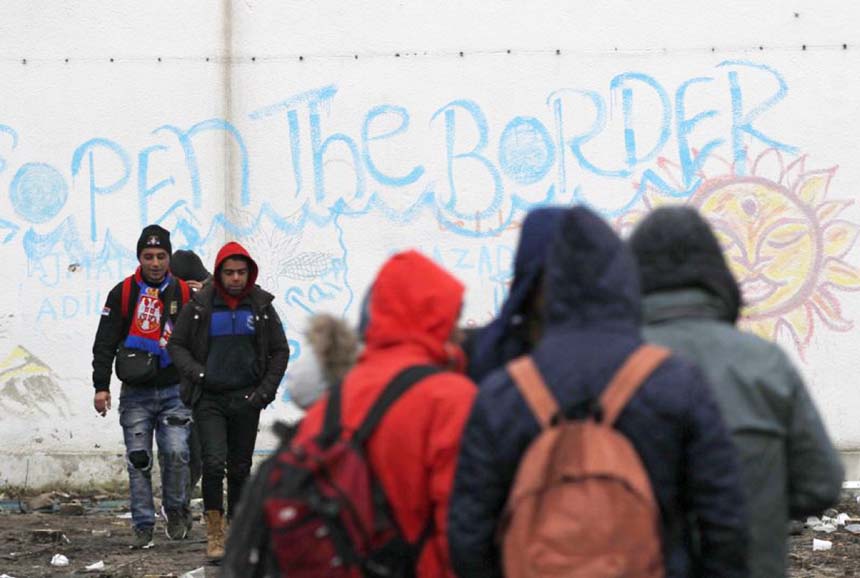 Migrants queue for food in an abandoned factory in the western Serbian town of Sid, near Serbia's border with European Union member Croatia on Monday.