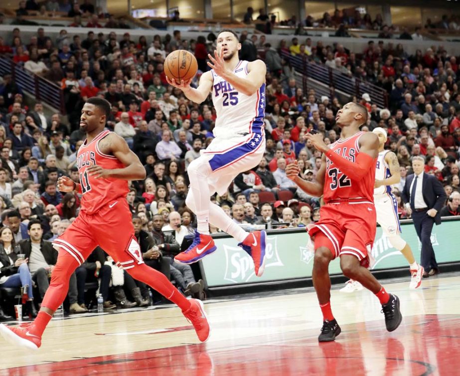 Philadelphia 76ers' Ben Simmons (25) drives to score past Chicago Bulls' David Nwaba (11) and Kris Dunn during the second half of an NBA basketball game on Monday.