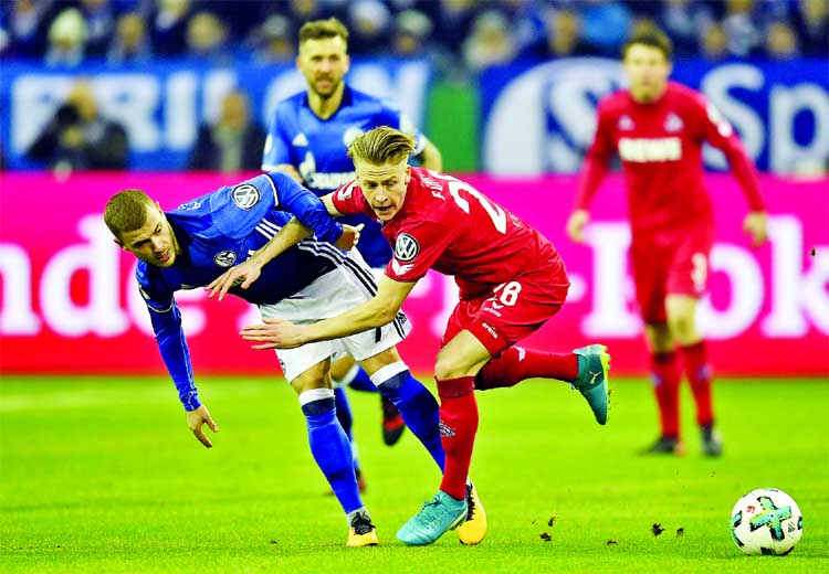 Schalke's Max Meyer, left, and Cologne's Chris Fuehrich challenge for the ball during the German soccer cup match between FC Schalke 04 and 1. FC Cologne in Gelsenkirchen, Germany on Tuesday.