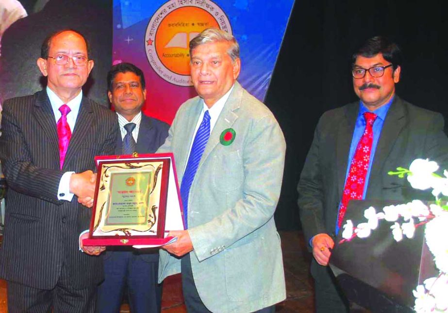 Masud Ahmed, Comptroller and Auditor General of Bangladesh, handing over a crest of honor to the State Minister for Finance and Planning Mohammad Abdul Mannan at a family get-together programme of employees of Audit and Accounts Department of AG office at