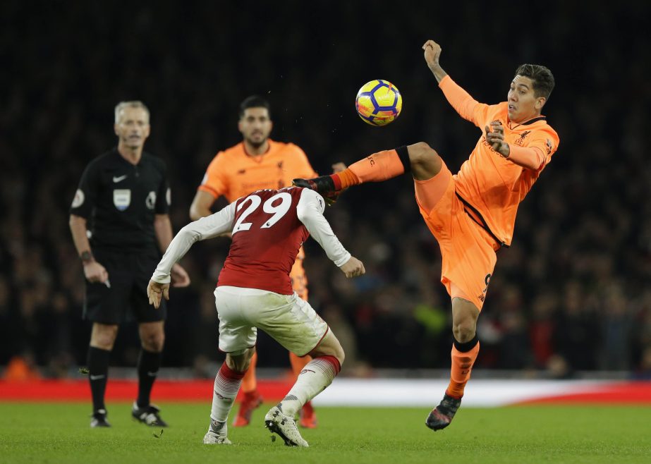 Liverpool's Roberto Firmino (right) vies for the ball with Arsenal's Granit Xhaka during their English Premier League soccer match between Arsenal and Liverpool at the Emirates stadium in London on Friday.