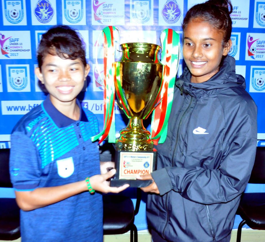 Captain of Bangladesh Under-15 National Women's Football team Maria Manda (left) and Captain of India Under-15 National Women's Football team Bannya Kabiraj pose with the trophy of the SAFF U-15 Women's Championship at the conference room in the BFF Ho