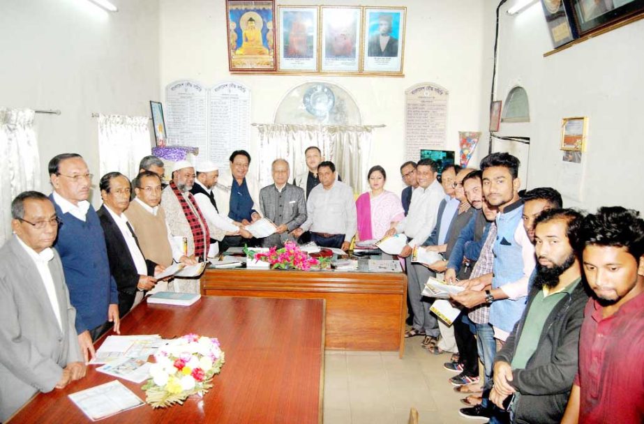 Social worker Farid Mahmud handing over leaflet on development activities of government to Ajit Ranjan Barua, Chairman, Bangladesh Buddhist Association at Buddha Mandir in Chittgaong recently.